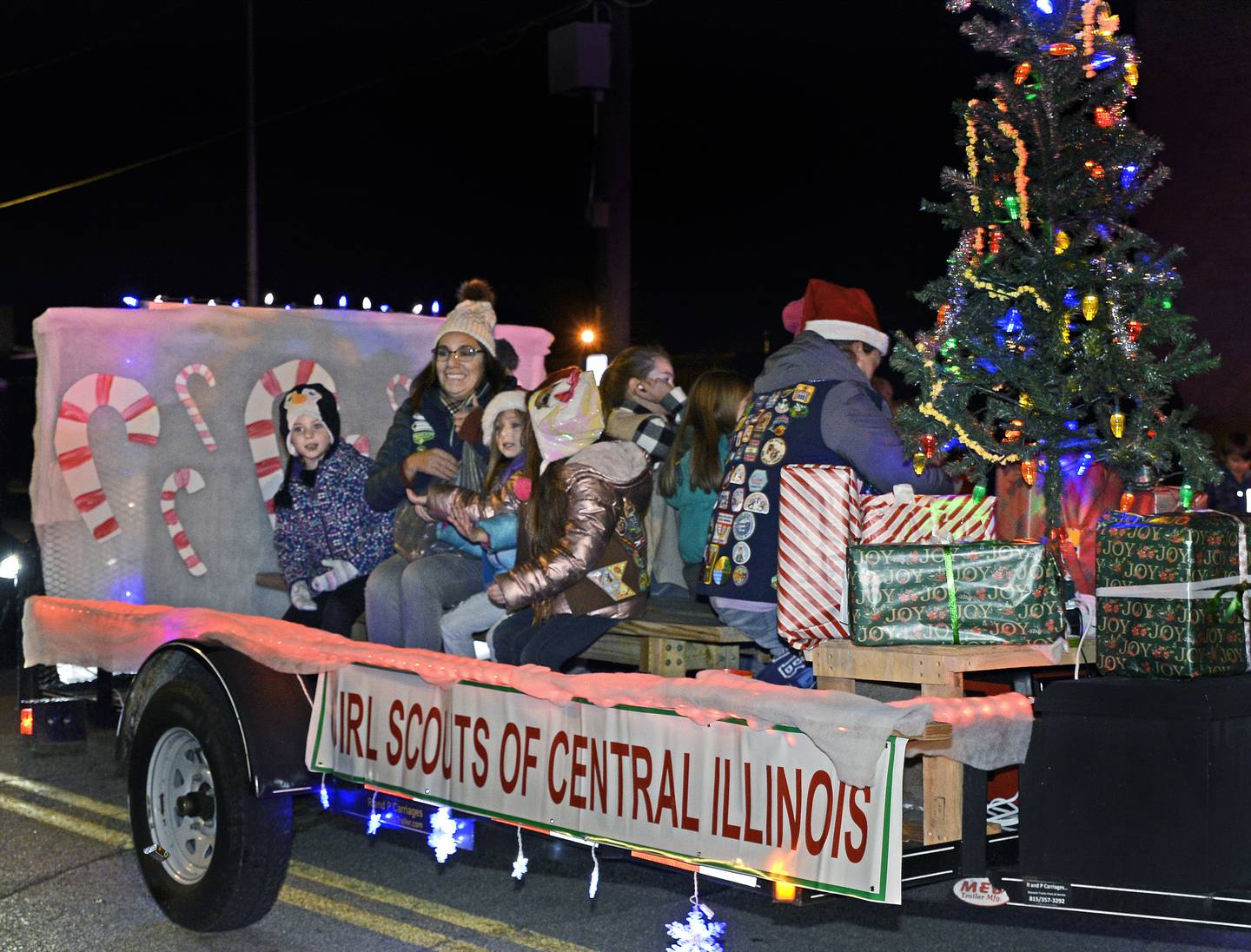 The Girl Scouts of Central Illinois ride on a trailer Saturday, Dec. 4, 2021, along Main Street in Marseilles during the annual Holiday Magic Lighted Santa Parade.