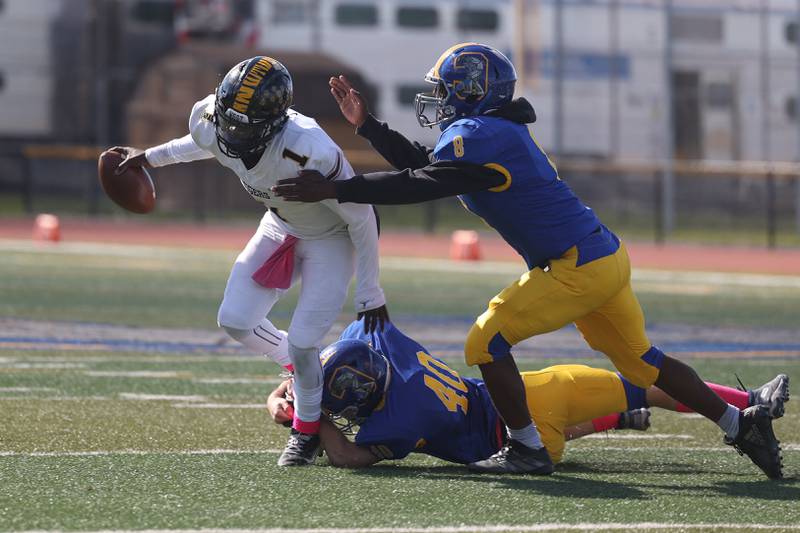 Joliet Central’s Guiness Goin (40) Jaylen Murphy and (8) bring down Joliet West’s Carl Bew for a sack on Saturday.
