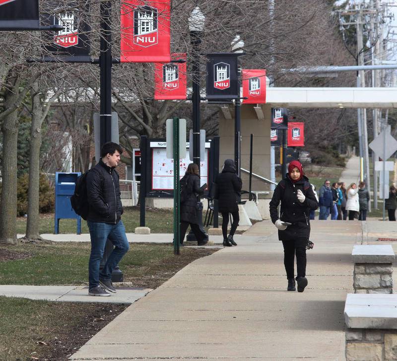 Students make their way around campus Friday, April 6 at Northern Illinois University in DeKalb.