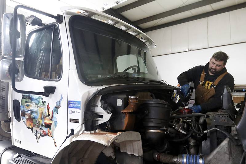 Andy Linic, the shop manager at Basic Logistics in Crystal Lake, performs maintenance on one of the company’s trucks on Friday, March 31, 2023, before it is used to make a delivery.