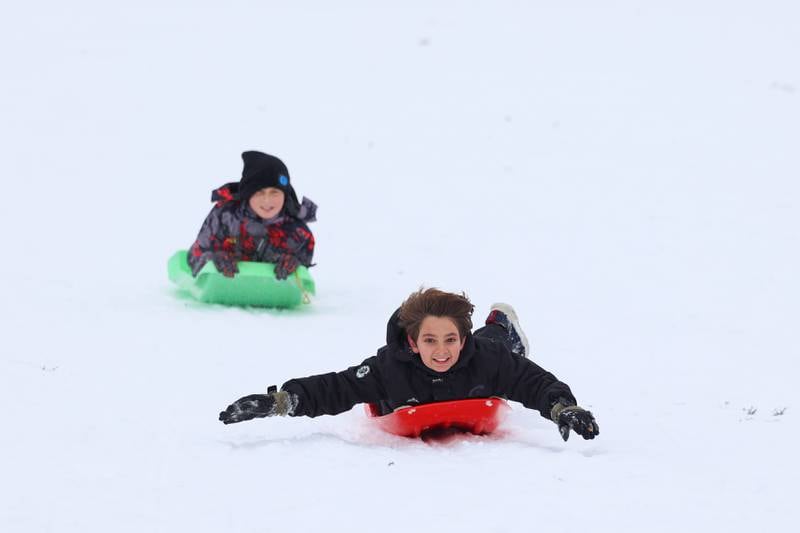 Cristian Villafuerte, 9, of Kankakee, leads the way ahead of friend Jace Corbin, 9, of Bradley, as they sled down the hill at Helgeson Park in Bradley on Sunday, Nov. 30, 2025.
