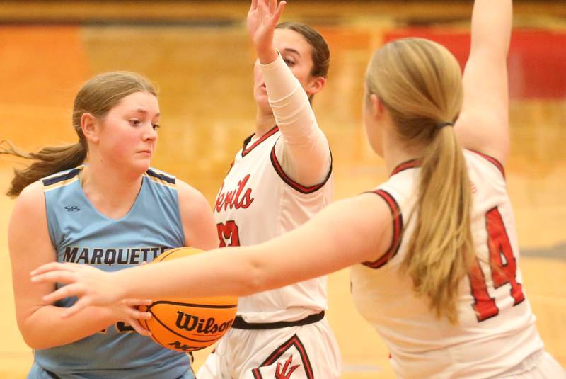 Marquette's Kelesy Cuchra works her way in the lane as Hall's Jocelyn King and teammate Kennedy Wozniak defend on Thursday, Feb. 13, 2025 at Hall High School.