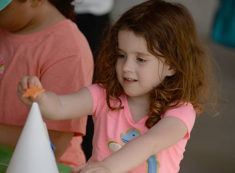 Children includingElelyn Taglia of Downers Grove decorate party hats during the Downers Grove Park District's 75th anniversary party at McCollum Park Saturday, May 14, 2022.