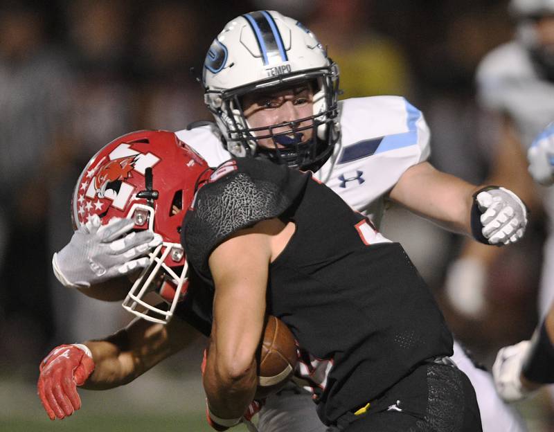 Prospect’s Conor Mitchell wraps up Maine South’s Michael Dellumo in a Thursday night football game in Park Ridge on September 15, 2022.