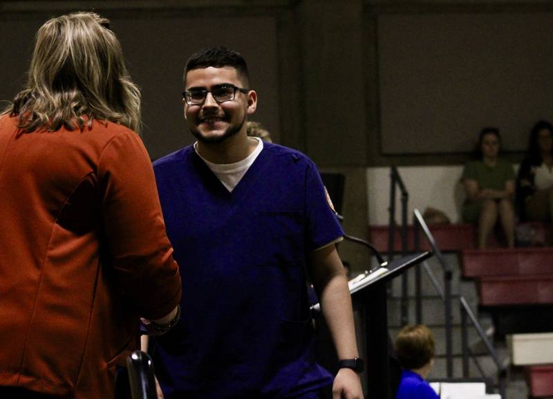 Associate degree in nursing candidate Alejandro Escalante crosses the podium on Friday during the pinning ceremony for the division of health professions at Sauk Valley Community College.