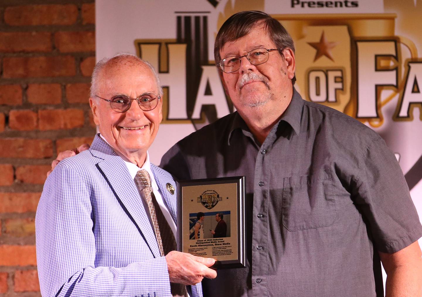 Lanny Slevin Emcee, presents the Shaw Media distinguished media award to Bureau County sports editor Kevin Hieronymus during the Shaw Media Illinois Valley Sports Hall of Fame on Thursday, June 8, 2023 at the Auditorium Ballroom in La Salle.
