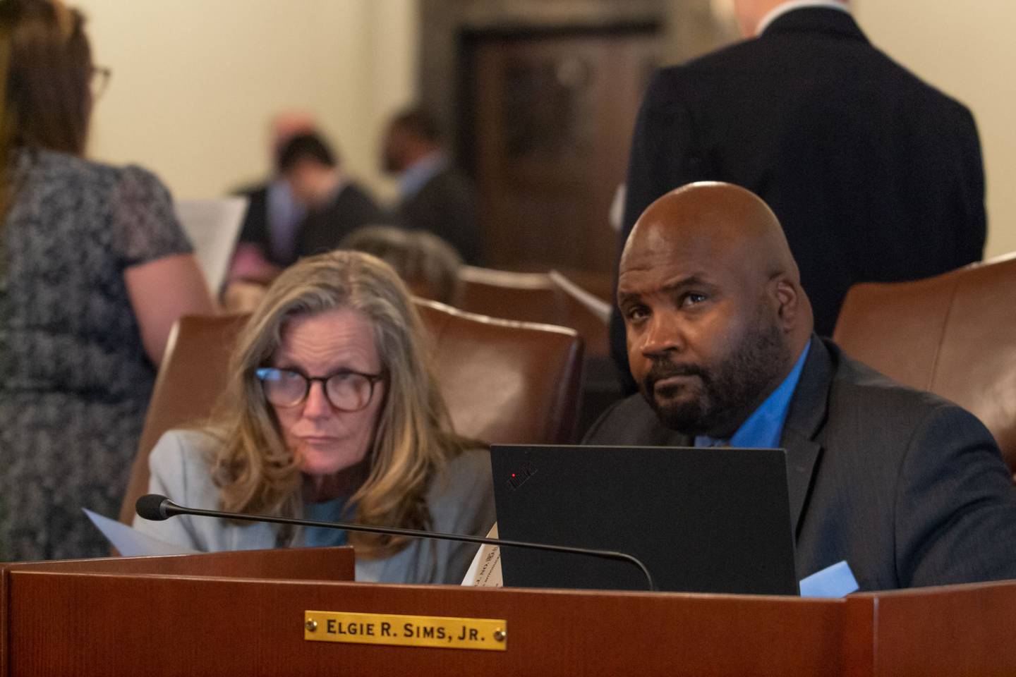 Sens. Laura Ellman, D-Naperville, and Elgie Sims, D-Chicago, watch floor debate on the Senate video board Sunday night. Sims sponsored the state budget bill, which proposes spending $53.1 billion. It passed the Senate Sunday night and heads to the House, where leaders expect it to pass.