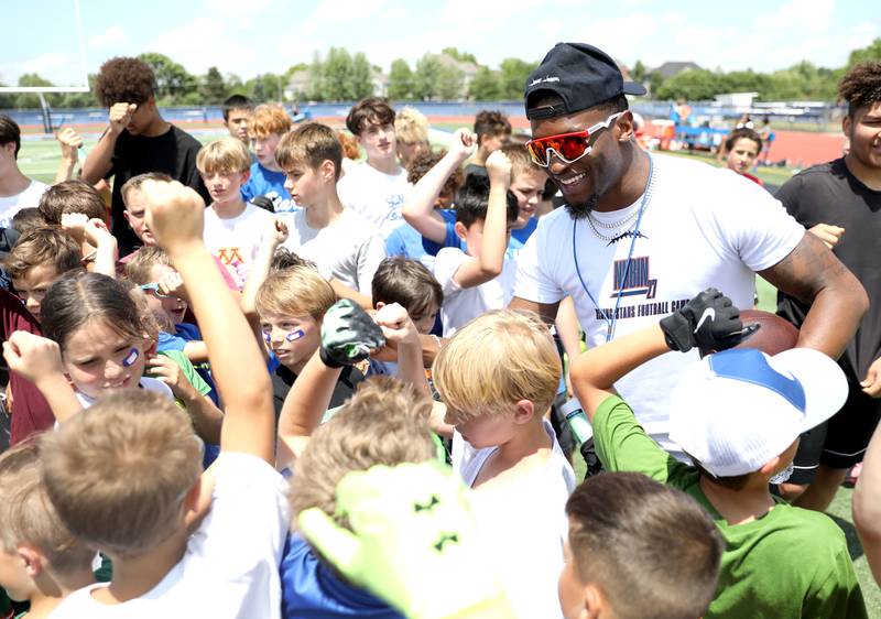 Former St. Charles North standout and current New York Giants defensive back Tyler Nubin huddles with young players on the first day of a three-day football camp on Friday, June 20, 2025 in St. Charles.