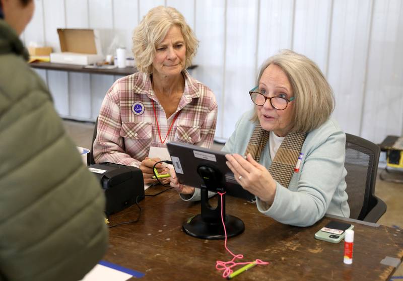 Election Judges Hilary McGrath (right) and Jodie Cleveland assist a voter in the 2024 general primary election at the DuPage County Fairgrounds in Wheaton on Tuesday, March 19, 2024.