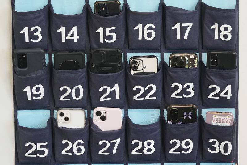 FILE - A phone holder hangs in a classroom at Delta High School, on Feb. 23, 2024, in Delta, Utah, at a rural school, where there is a strict policy requiring students to check their phones at the door when entering every class. (AP Photo/Rick Bowmer, File)