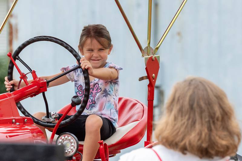 Morgan Cissell sits on tractor at the 21st annual Convoy Against Cancer on Saturday, July 19, 2025 on Main Avenue in Ladd.