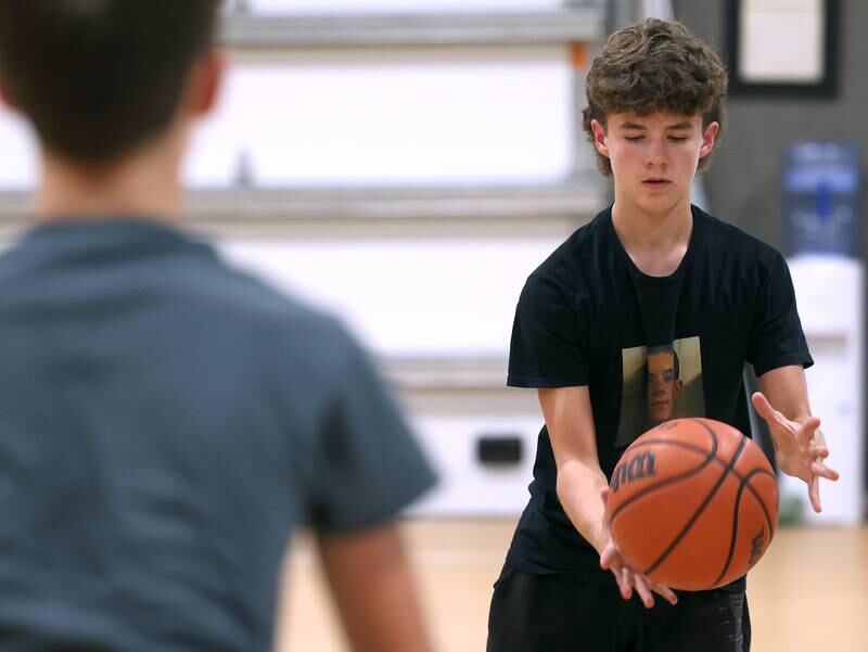 Caleb Krueger, (left) 13, and his brother Cole, 15, from Genoa, show off the passing technique Wednesday, Aug. 28, 2024, that earned them the Guinness World Record record for the most basketball passes in a minute for a pair under 16. The two are planning an attempt at breaking the world record for the most three pointers in a minute by a duo.