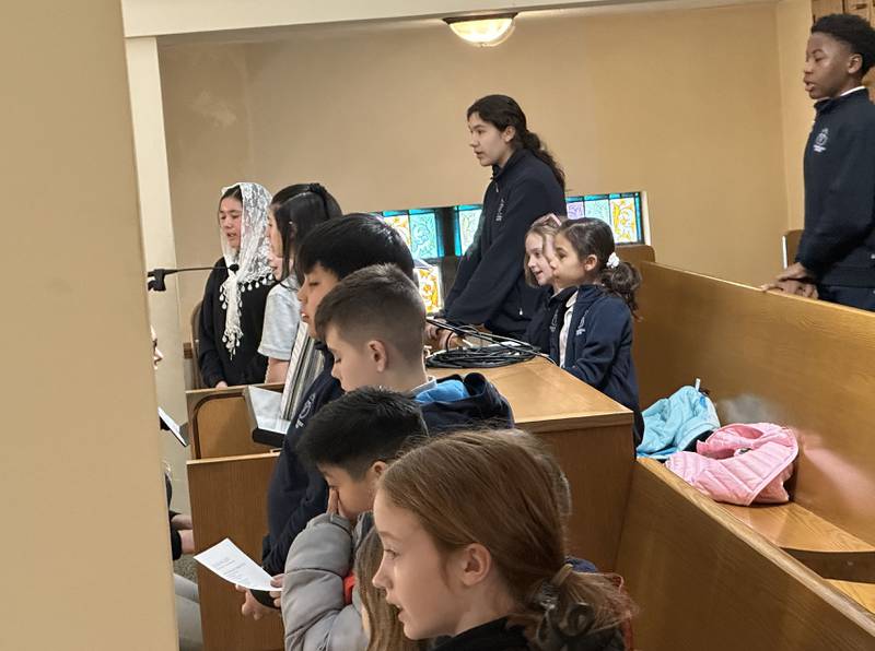 Trinity Catholic Academy students sing from the choir loft on Wednesday, March 5, 2025 during Ash Wednesday Mass at Queen of the Holy Rosary Church in La Salle.