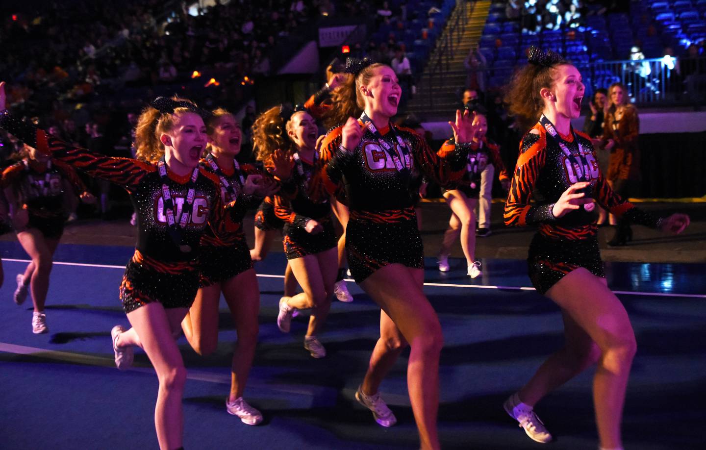 Crystal Lake Central team members rush to receive their first-place medium team trophy during the IHSA competitive cheerleading state finals at Grossinger Motors Arena in Bloomington Illinois on Saturday, Feb. 5, 2022.