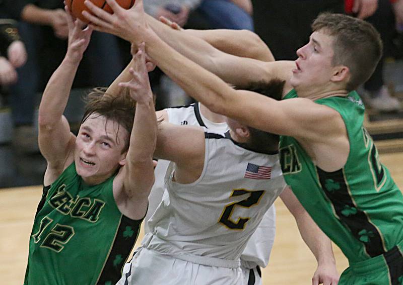 Seneca's Braden Ellis (left) and Lane Provance (right) take away a rebound over Putnam County's Andrew Pyszka (center) on Friday, Dec. 16, 2022 at Putnam County High School.