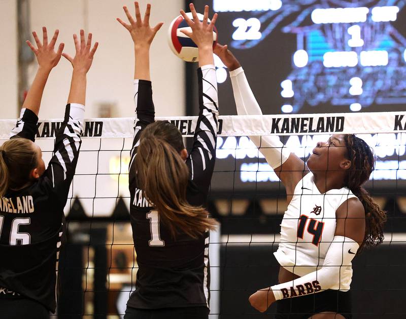 DeKalb's Jordan Grant tries to spike the ball by Kaneland's Francesca Rio (left) and Grace Remsen Thursday, Sept. 4, 2025, during their match at Kaneland High School in Maple Park.