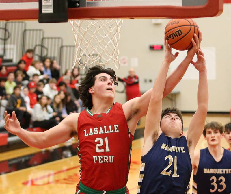 L-P's Josh Senica (21) and Marquette's Carson Zellers (21) fight over a rebound during the Colmone Classic tournament on Monday, Dec. 5, 2022 at Hall High School in Spring Valley.