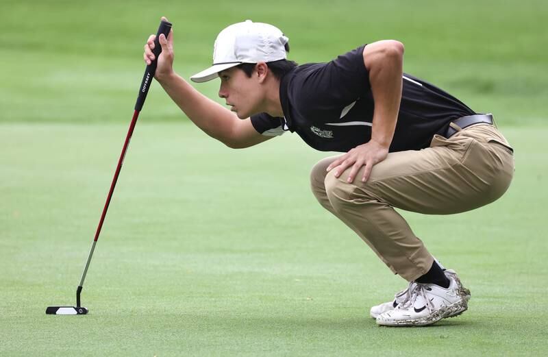 Kaneland’s Zach Ramos lines up a putt Wednesday, Sept. 27, 2023, during the Class 2A boys golf regional at Sycamore Golf Club.