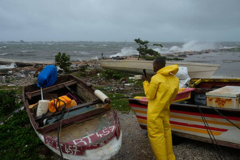 A man watches the coastline in Kingston, Jamaica, as Hurricane Melissa closes in, Tuesday, Oct. 28, 2025. (AP Photo/Matias Delacroix)