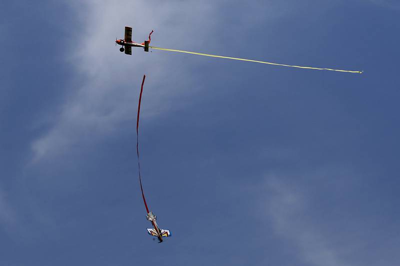 Two radio-controlled planes have a streamer dogfight on Thursday, Aug. 8, 2024, near Hebron.