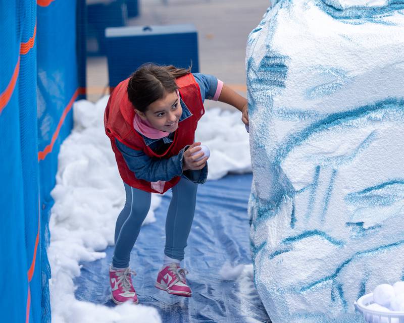 Child hides behind "glacier" the annual 'Ax Church Ultimate Snowball Fight' at Frosty on First on Saturday, November 8, 2025 on First Street in La Salle.