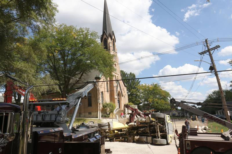 Crews with Scholles Body Shop use tow trucks to lift a cement truck out of a sinkhole on Tuesday, Sept. 2, 2025 at the intersection of Pulaski Street and 6th Streets in Peru.