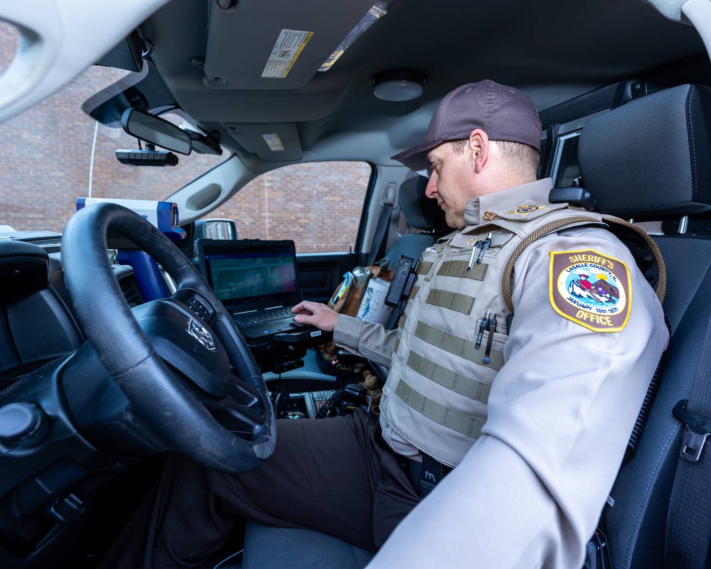 Newly graduated Deputy, Patrick Goetz types on Mobile Data Terminal inside  LaSalle County Sheriff Truck on Tuesday, December 23, 2025 at LaSalle County Correctional Sheriffs Office in Ottawa. Deputy Goetz is one of the 6 newly hired to the agency this December.