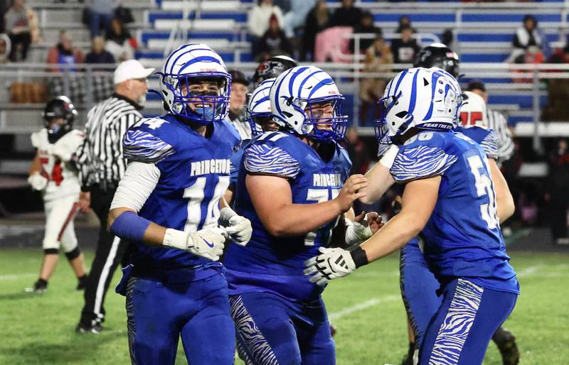 Princeton's Grady Cox (center) celebrates his interception with teammates Owen Hartman (right) and Jack Oester during the Tigers' 48-0 win over Erie-Prophetstown on Friday, Oct. 24, 2025 at Bryant Field in Princeton.