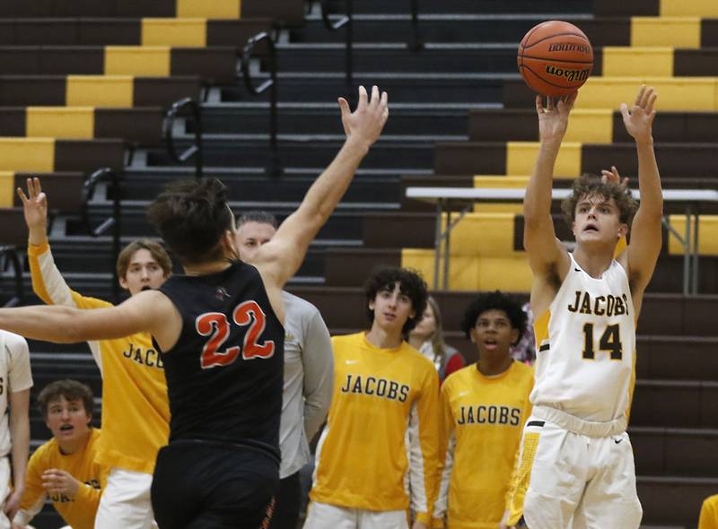 Jacobs' Brett Schlicker, left, shoots a three-pointer as McHenry's Conner McLean runs at him during a Fox Valley Conference basketball game Wednesday, Dec. 7, 2022, between Jacobs and McHenry at Jacobs High School in Algonquin.