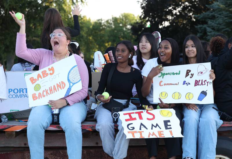 DeKalb High School tennis players wave to friends as they head down West Dresser Road Wednesday, Oct. 2, 2024, during the DeKalb homecoming parade.