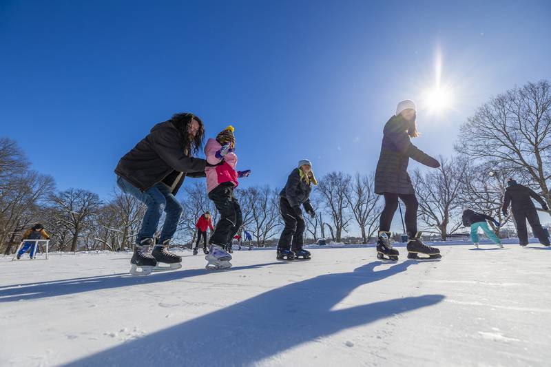 Bryce Goldie (left), helps up daughter Serenity Daley, 9, and Addison Lightner, 8, and Amber Moseley skate by Saturday, Jan. 20, 2024 in Dixon. The temps were in single digits but the sun was shining for a great first day of ice skating.