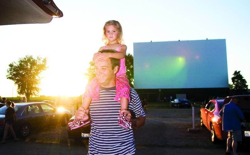 Halli Grout sits on her father Jim’s shoulders while waiting for a movie to start at the 2010 Petunia Festival’s Retro Night at Midway Drive-In and Diner between Sterling and Dixon. The Midway's owners, Mike and Mia Kerz, are trying to raise $40,000 by Feb. 28 in the first phase of a fundraising campaign to help pay for the digital projector and other updates that must be made to accommodate the use of the new equipment. Movie studios have stopped distributing movies on 35mm film.