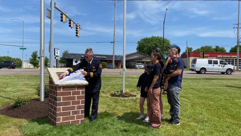 DeKalb County Sheriff Andy Sullivan joined by loved ones of the late Deputy Christina Musil unveils a memorial plaque  to honor Musil at the new first responders memorial outside Isaac Executive Suites, 2675 Sycamore Road, DeKalb, during a dedication ceremony held Sunday, May 19, 2024. Musil, 35, a mother of three and military veteran, was killed in the line of duty after a car crash March 28, 2024. She died from her injuries in the early morning hours March 29, 2024.
