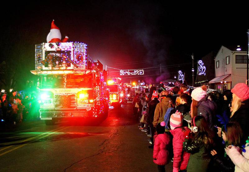Visitors crowded along Main Street in downtown Oswego last year to see the spectacle of the Christmas Walk's annual Illuminated Silent fire truck parade.