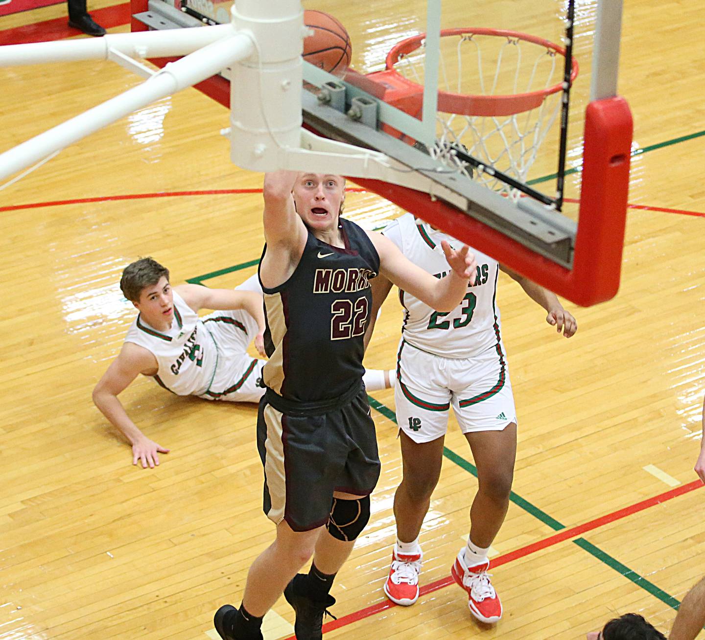 Morris' Gage Phillips (22) runs in the lane past L-P's Seth Adams and Maalik Madgrigal to score on a layup in Sellett Gymnasium on Friday, Jan. 13, 2023, at L-P High School.