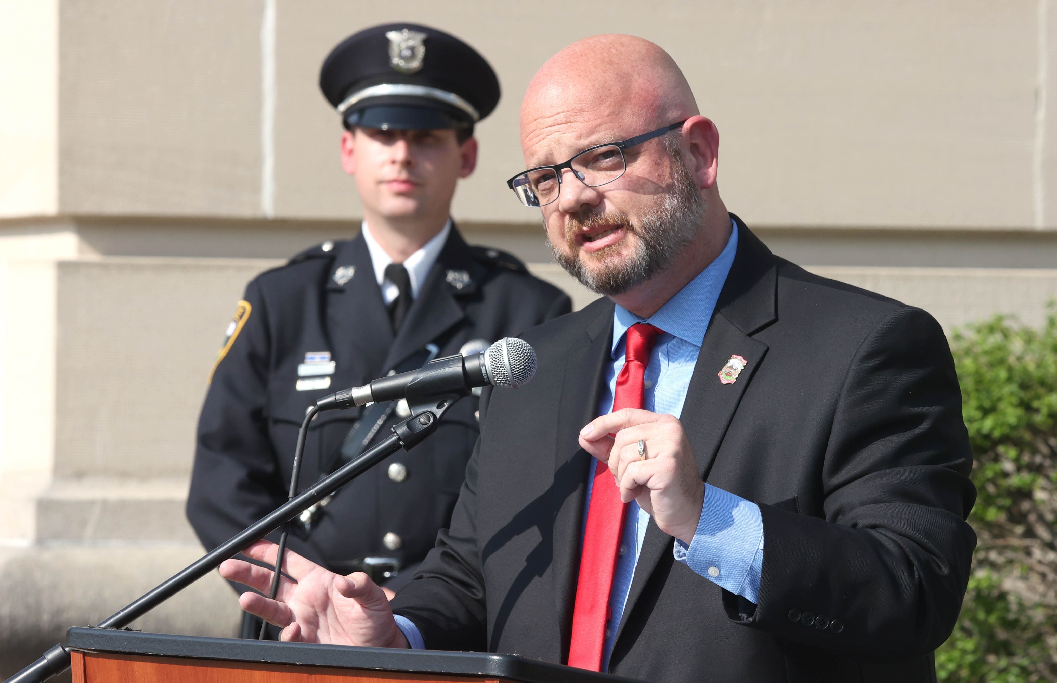 State Rep. Jeff Keicher, R-Sycamore, speaks as Sycamore Police Department detective Ryan Hooper looks on Friday, May 13, 2022, during the DeKalb County Law Enforcement Officers' Memorial Service on the lawn of the DeKalb County Courthouse in Sycamore.