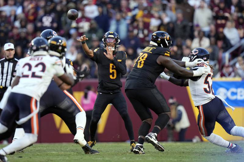 Washington Commanders quarterback Jayden Daniels (5) passes against the Chicago Bears in the first half of an NFL football game Sunday, Oct. 27, 2024, in Landover, Md. (AP Photo/Stephanie Scarbrough)