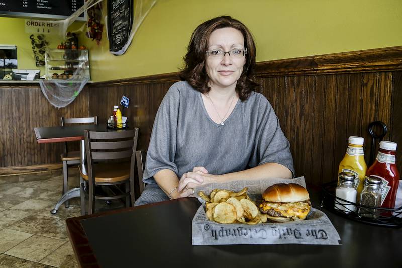 Hamburgerseria owner Elina Triantou displays one of the menu offerings at her Joliet restaurant.