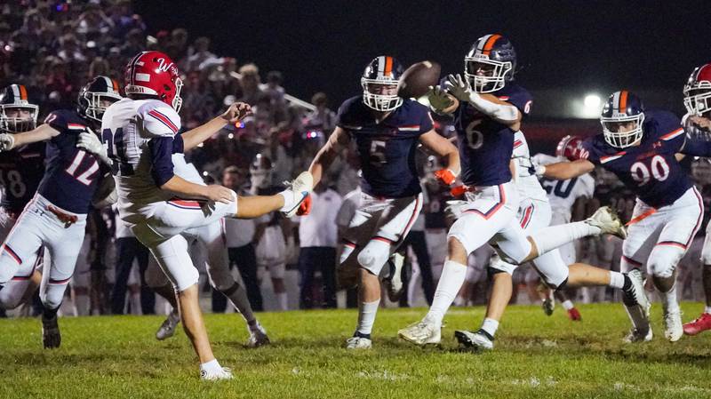 Oswego’s Michael Claycombe (6) attempts to block a punt by West Aurora's Carter Velez (31) during a football game at Oswego High School on Friday, Sept. 29, 2023.