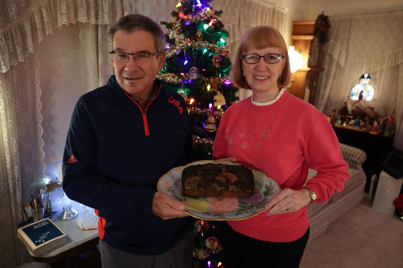 Craig and Sarah Randolph of Joliet hold the 100-plus year-old fruitcake that has been passed down from her family on Thursday, Dec. 8, 2022 in Joliet.