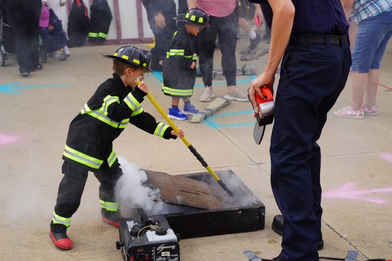 Junior firefighter demonstrates removing smoke from a roof prop by making a hole at the Plainfield Fire Protection District open house on Saturday, Sept. 16.