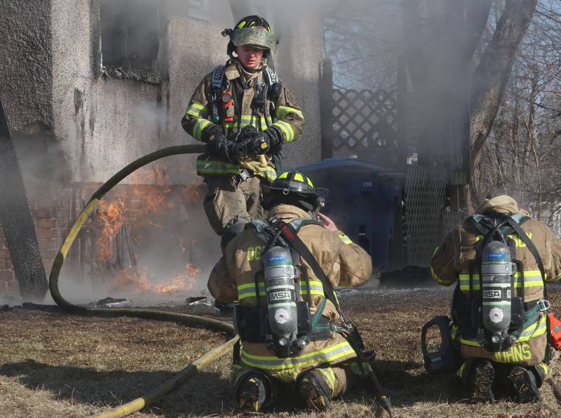 Oglesby firefighter John Lemmer (top) carries a hose away from a buring house in the 800 block of Bucklin Street on Friday, Jan. 23, 2026 in La Salle.