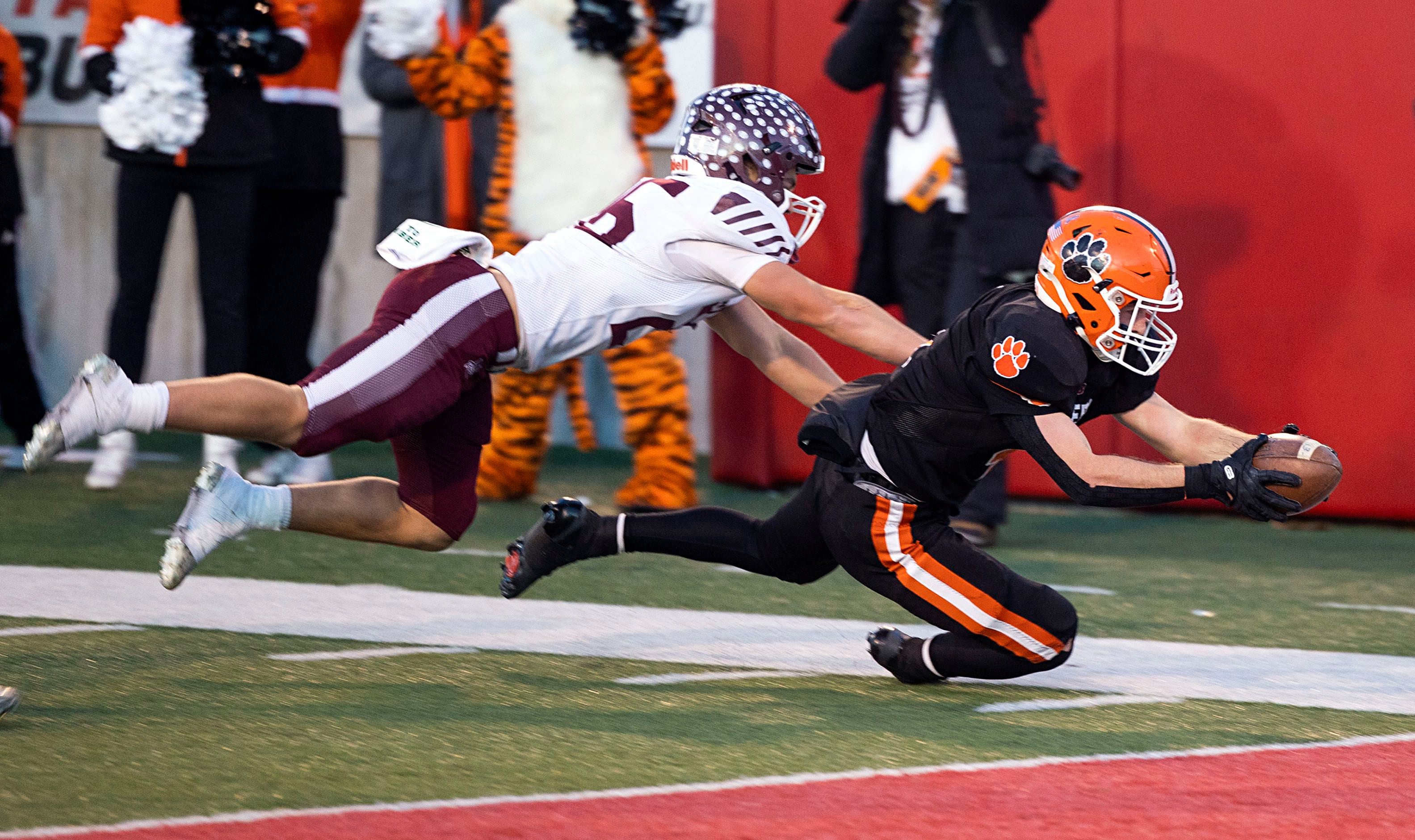 Byron’s Dawson Criddle dives for the end zone against Tolono-Unity's Keegan Germano Friday, Nov. 28, 2025, in the Class 3A football finals at Hancock Stadium at ISU.