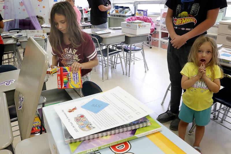 Jaylin Schoenbeck, a fourth grader, at Duker Elementary School in McHenry, puts her school supplies in her desk on Tuesday, Aug. 15, 2023, during school supplies drop-off day.