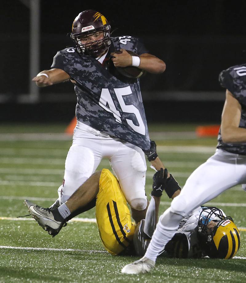 Richmond-Burton's Braxtin Nellessen runs through the tackle attempt to Harvard's Edward Rosales during a Kishwaukee River Conference football game on Thursday, Oct.12, 2023, at Richmond-Burton High School.