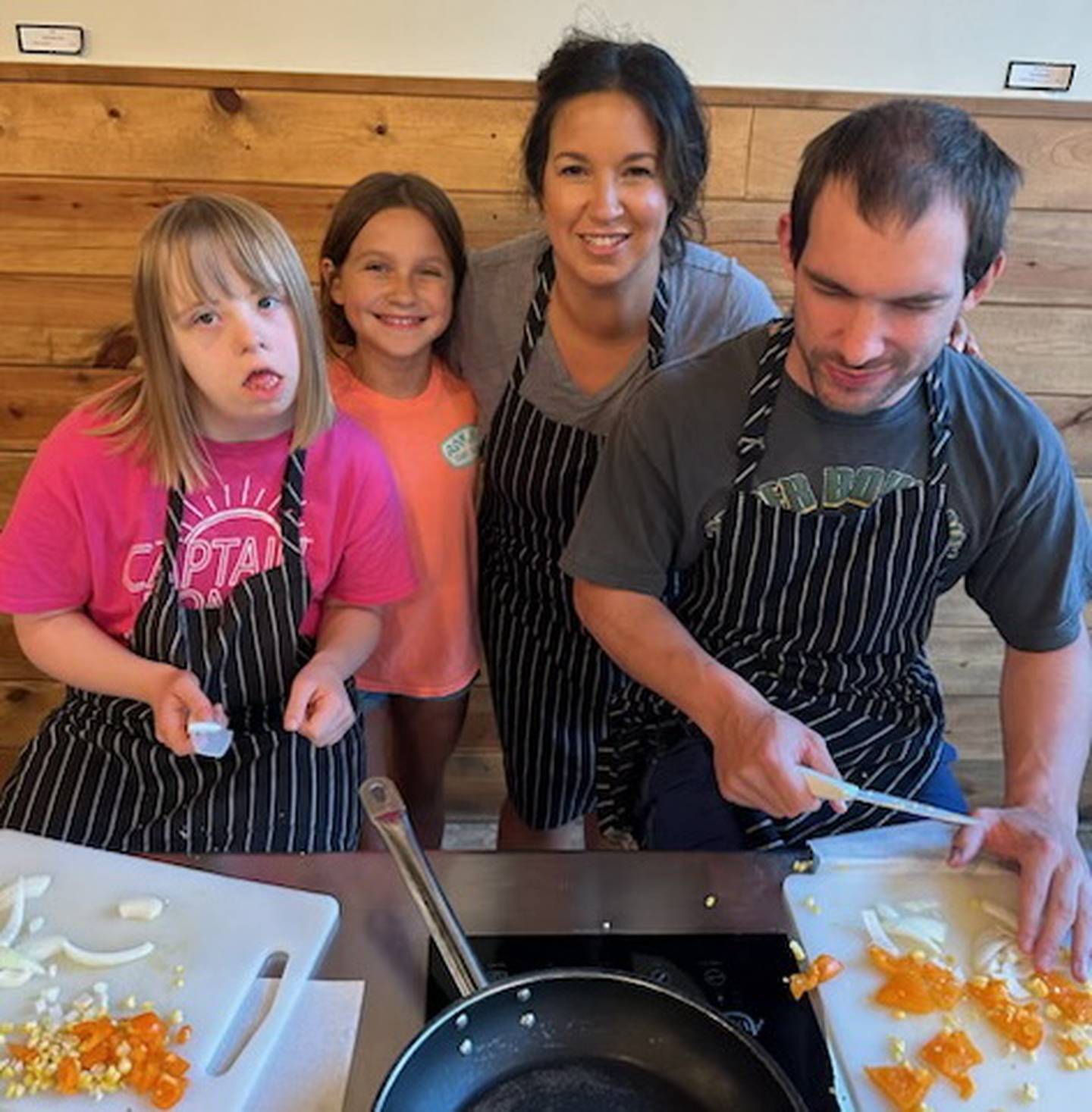 Jillian Dennis (left), of Elburn, Juliana Valentini, daughter of Rising Lights Program founder Jaimie Valentini and Scott Dauksha of Batavia, chop yellow peppers, onion and garlic for homemade pumpkin chili during a cooking class. The Rising Lights Program is a nonprofit in St. Charles that serves adults with disabilities with opportunities for socialization and education.
