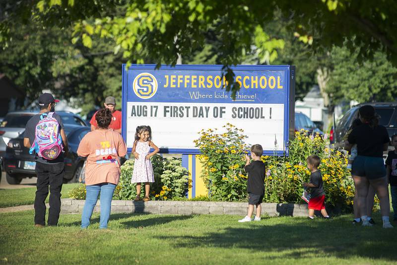 Students and parents gather around the Sterling Jefferson School sign to have pictures taken Wednesday, Aug. 17, 2022 for the first day of school.