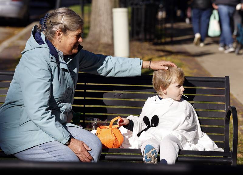 Joyce Elliott of Geneva sits grandson Emmett Elliott, 3, of Warrenville as he enjoys some of his rewards from  trick-or-treating Thursday, Oct. 30, 2025 in Geneva.