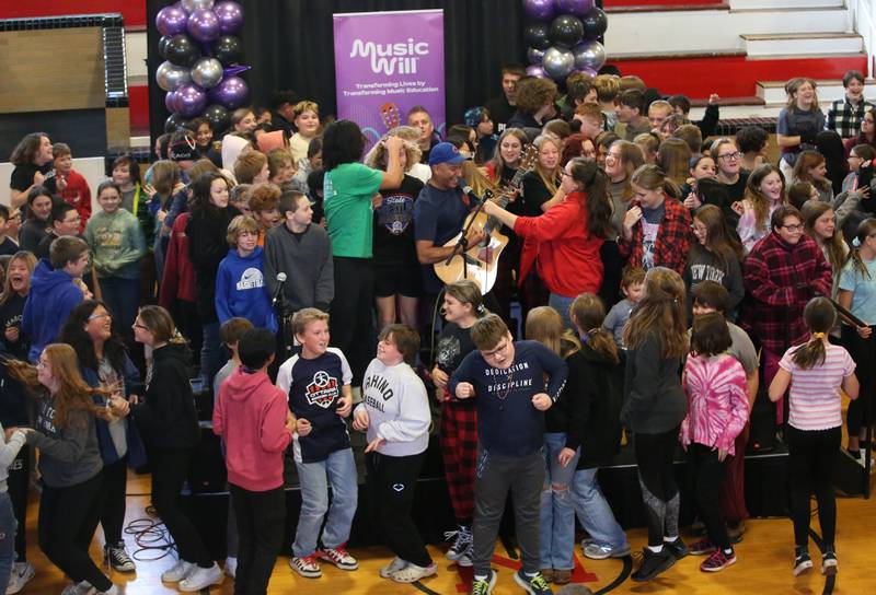 Tom Morello (center) performs with students at Marseilles Elementary School on Thursday, Nov. 30, 2023. Morello is best known for his tenure with the rock bands Rage Against the Machine and Audioslave. Morello grew up in Marseilles before making it to the major music industry.