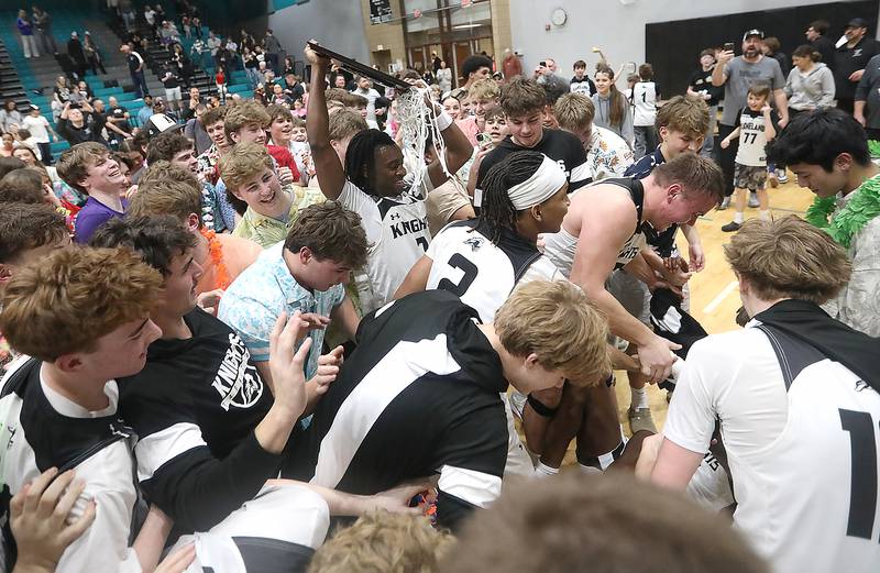 Kaneland's Marshawn Cocroft raise the trophy as hi I swarmed by teammates and fane after Kaneland defeated Crystal Lake South in the IHSA Class 3A Woodstock North Sectional final basketball game on Friday, March 6, 2026, at Woodstock North High School.